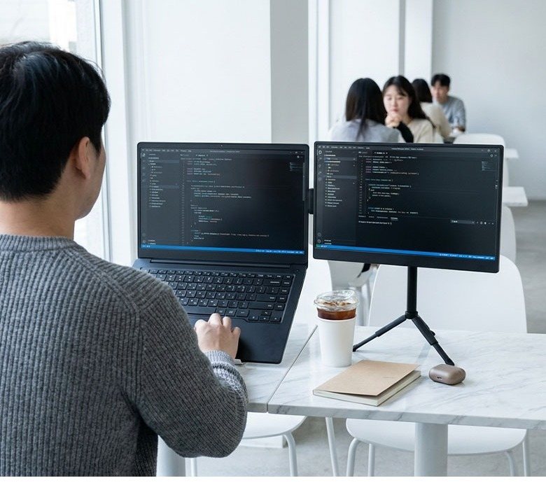 카페에서 듀얼 모니터로 작업하는 모습